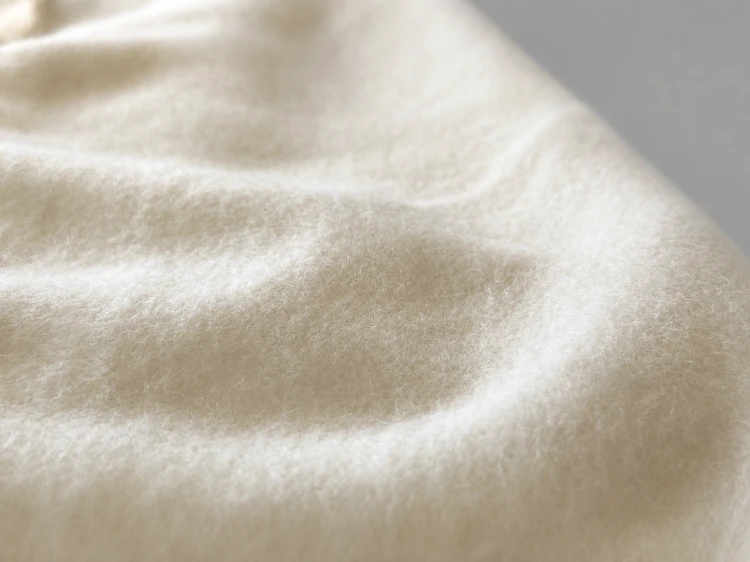 Zbliżenie na miękką strukturę materiału bluzy premium w kolorze ecru. Wysokogatunkowa bawełna zapewnia komfort noszenia, trwałość oraz przyjemne wykończenie idealne na każdą porę roku.